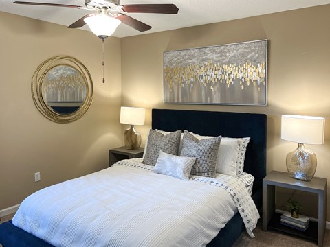a bedroom with a large bed and a ceiling fan at Reserve of Bossier City Apartment Homes in Bossier City, LA 